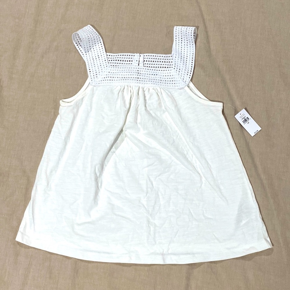 Flowy white top with crochet detail.